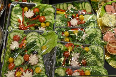 Plastik ambalajda hazır salatalar. Sağlıklı bir fast food. Marketin tezgahında sebze salatası var. Vejetaryen yemeği, diyet. Yemek teslimatı
