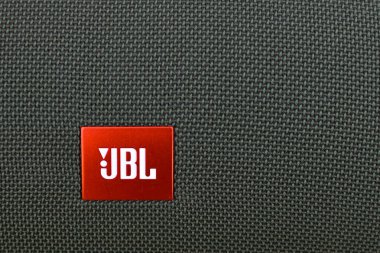 JBL koyu yeşil bluetooth hoparlörü. Kumaş hoparlörlerinin yakın çekim dokusu. Makro mod. Logo JBL - akustik üreten Amerikan şirketi. Amblemle örülmüş yüzey. Rusya, Novosibirsk-Nisan 10.2021