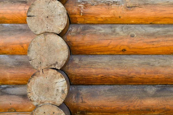 Texture of wall of house made of rounded logs. facade of log house, space for text. Wooden log wall built from smoothly polished logs. Construction of houses from natural materials. Wooden frame