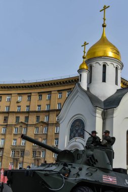 Beyaz şapelin arka planına karşı tank. Askeri teçhizat şehrin boş sokaklarından geçiyor. 9 Mayıs 'taki Zafer Yürüyüşü hazırlıkları. Novosibirsk, Rusya - 05.05.2021.