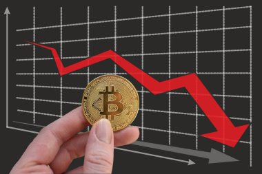 El, düşen grafiğin arka planında kırmızı okla bitcoin tutuyor. Döviz kurunda düşüş. Haritanın arka planında kırmızı ok ve altın bitcoin var. Kripto para biriminde bozulma. Bitcoin İndeks Sıralaması.