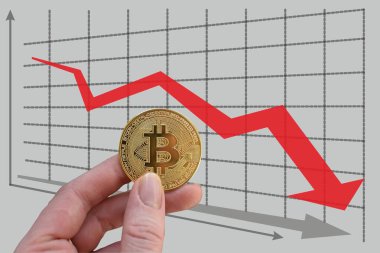 El, düşen grafiğin arka planında kırmızı okla bitcoin tutuyor. Döviz kurunda düşüş. Haritanın arka planında kırmızı ok ve altın bitcoin var. Kripto para biriminde bozulma. Bitcoin İndeks Sıralaması.