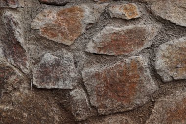 Taştan el yapımı taş ustası. Büyük taşların dokulu arkaplanı. Büyük taşlardan oluşan antik bir duvar, askeri kuvvetler. Duvarın soyut bir dokusu. Masonluk taşı keyfi şekil. Boşluğu kopyala