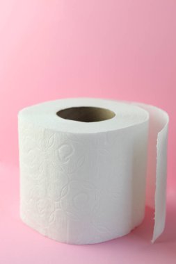Pembe arka planda yumuşak beyaz tuvalet kağıdı rulosu