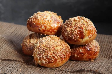 Ekmek ruloları koyu rustik arka planda, çuval bezinde.