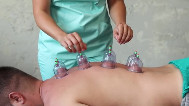 Vrouwelijke Therapeut Doet Cupping Therapie Met Plastic Cups Door Zuigen — Stockvideo