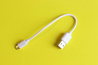 Sarı arkaplanda izole edilmiş kısa beyaz usb kablosu.