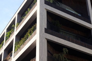 Her balkonda verimli yeşillik bulunan modern mimari yapı, kentsel sürdürülebilirliği ve tasarımda doğa bütünlüğünü yansıtıyor.