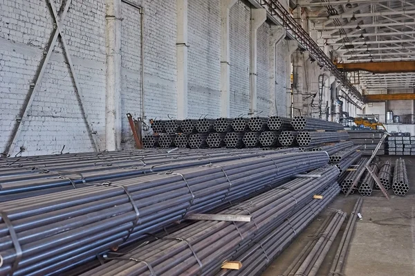 Metal borular bir depoda. Yığınlar SK yeni yuvarlak çelik borunun