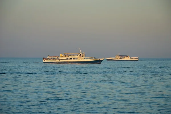 Białe łodzie z ludźmi na Morzu Czarnym — Zdjęcie stockowe