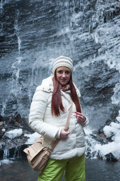 Mujer parada cerca de la cascada de montaña — Foto de Stock