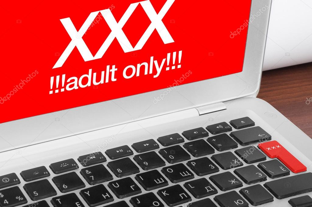 Online porn concept. XXX adults only message on silver laptop an