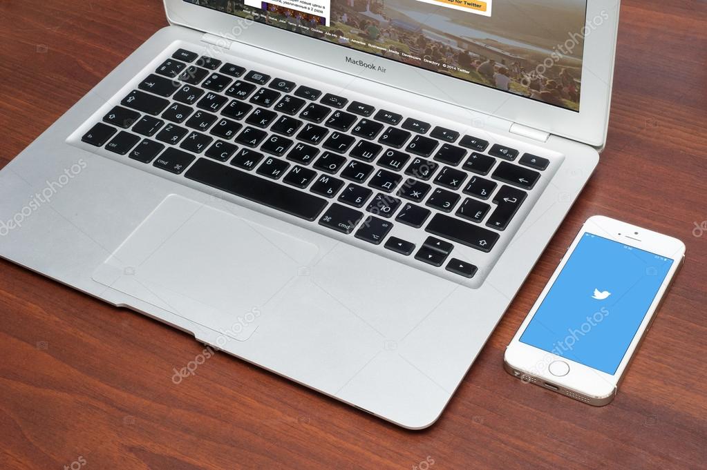 Pavlograd, UKRAINE - December 18 2014: brand new Apple iPhone 5S with Twitter logo on the screen and twitter page on laptop. Twitter is a social media online service for microblogging and networking communication.