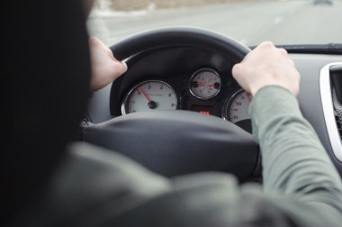 Bir arabayı kullanan adam. El bir araba direksiyon simidi üzerinde.