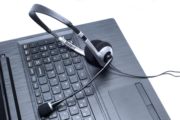 Sluchátka na počítačové klávesnici notebooku — Stock fotografie