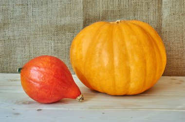 Autumn red pumpkin on a wooden background in a rustic style