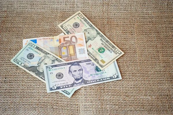 Dollars on a burlap background — Stock Photo, Image