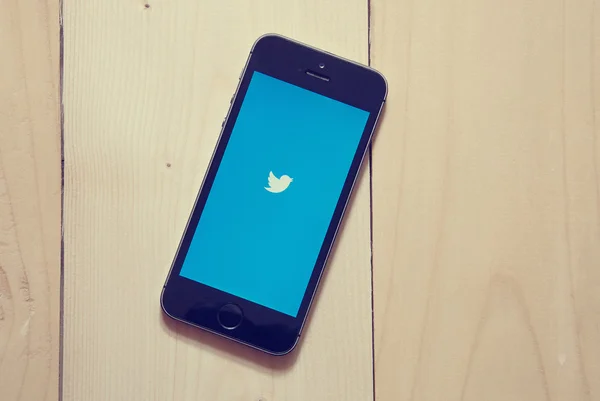 IPhone with Twitter app on wooden background — Stock Photo, Image