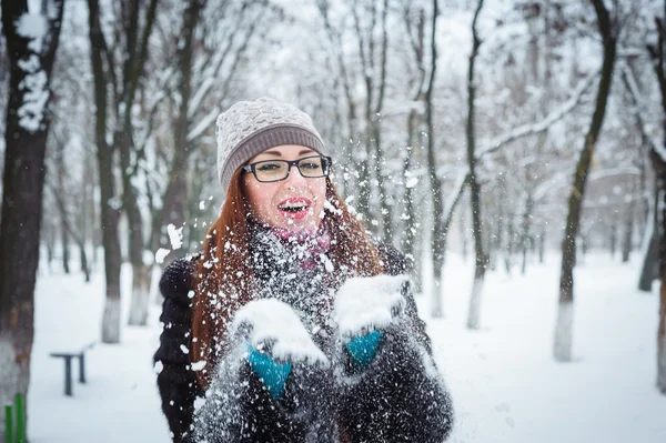 Belleza chica de invierno soplando nieve en el parque de invierno helada — Foto de Stock