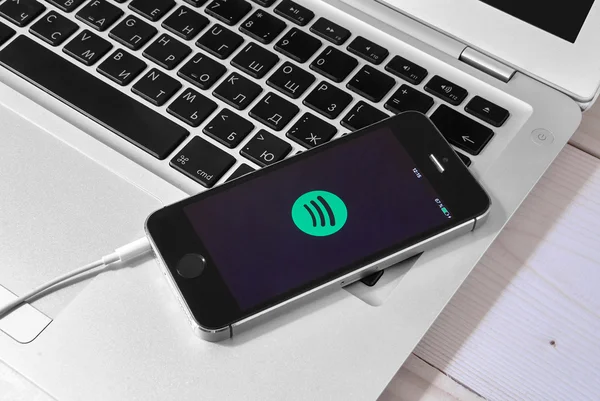 IPhone 5s on laptop with mobile application for Spotify on the s — Stock Photo, Image
