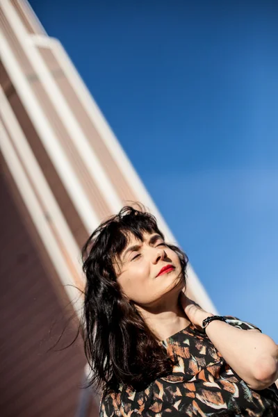 Young woman with red lipstick on the roof watching ahead — Stock Photo, Image