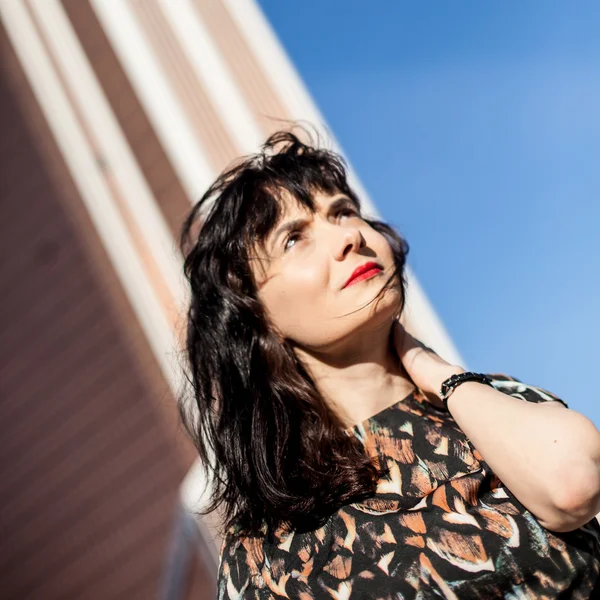 Young woman with red lipstick on the roof watching ahead — Stock Photo, Image