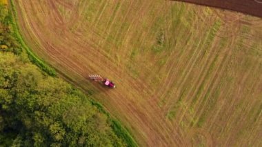 Bir çiftlik alanı drone görünümünde çalışan traktör