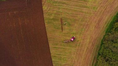 Bir çiftlik alanı drone görünümünde çalışan traktör