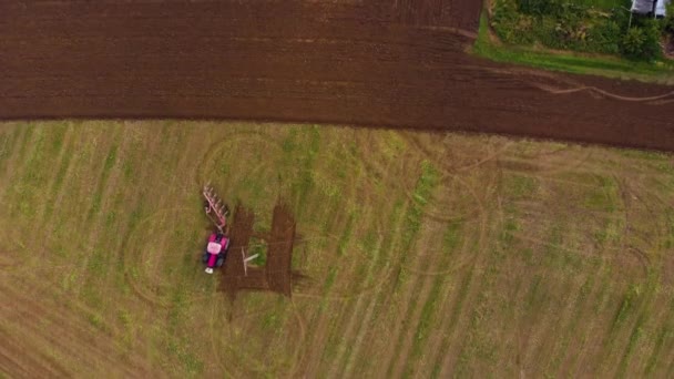 Traktor arbetar en gård fält drönare vy — Stockvideo