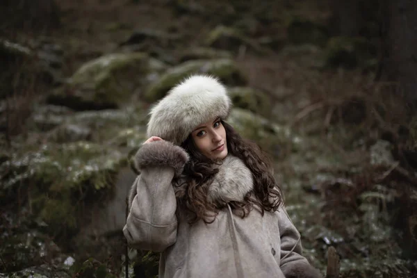 Retrato de una mujer con sombrero de piel y chaqueta de cuero.Caliente en los alrededores del bosque. —  Fotos de Stock