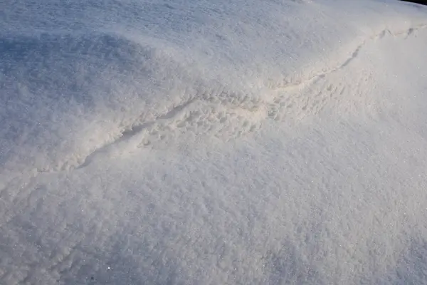 Oberfläche aus reinem weißen Schnee mit Unebenheiten. Winterbild. — Stockfoto