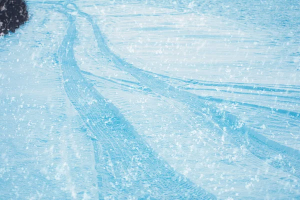 Spuren im frischen Schnee. Schneeflocken im Vordergrund. Winterbild. — Stockfoto