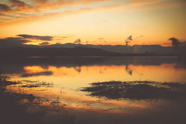 Gyönyörű naplemente a tó felett télen. Hegyek a háttérben. — Stock Fotó