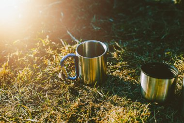 Dağlardaki çayırlarda iki metal bardak. Yürüyüş konsepti..