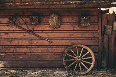 Hayvan çiftliğindeki ahşap duvarda asılı eski köylü aletleri.