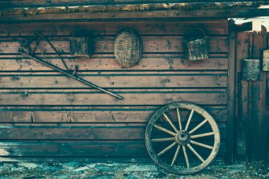 Hayvan çiftliğindeki ahşap duvarda asılı eski köylü aletleri.