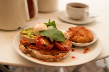İngiliz kahvaltısı, domuz pastırmalı tost, avokado ve beyaz tabakta yumurta. Yüksek kalite fotoğraf