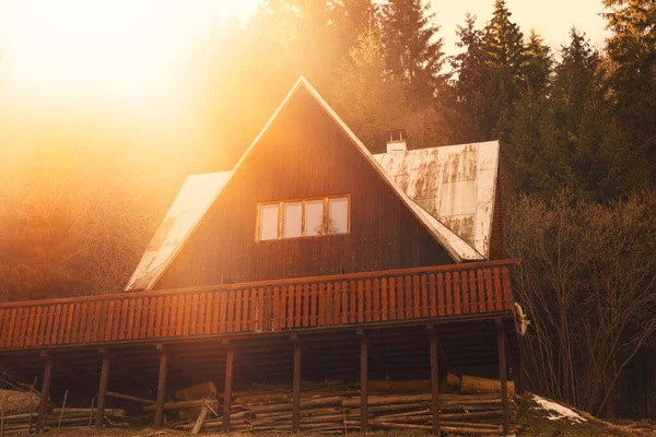 Houten huisje in het bos.Zon op de achtergrond.Hoge kwaliteit foto. — Stockfoto