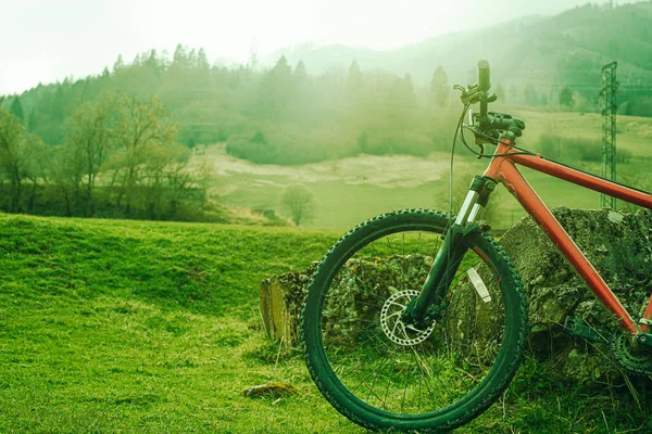 Mountain bike on the green field.Hills in background. — Stock Photo, Image