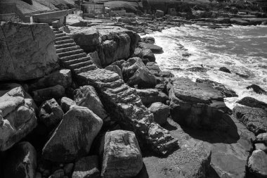 Arka planda deniz olan yalnız merdivenler.