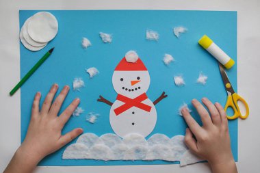 Çocuklar için el sanatları. Küçük çocuk kağıttan kış süsü yapıyor. Çocuk sanat projesi. Diy konsepti. Çocuklar için El Yapımı Kolay Kağıt El Sanatları