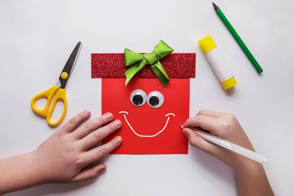 Małe dziecko robi świąteczne dekoracje Prezent z papieru. Projekt plastyczny dla dzieci. Koncepcja majsterkowania. Instrukcja fotograficzna krok po kroku. — Zdjęcie stockowe