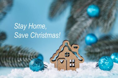 Evde Kal, Noel 'i Kurtar. Mavi Noel arkaplanındaki Noel ağacı oyuncak evi. Evde kalmak kavramı. Kapalı