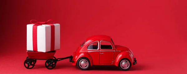 Czerwony Samochód Dostarcza Pudełko Czerwonym Tle Niespodzianka Dla Ukochanej Osoby — Zdjęcie stockowe