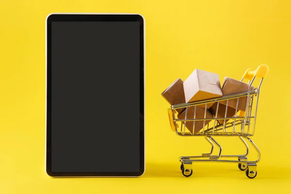 Concetti di shopping online. Cellulare. Dispositivo di comunicazione portatile. Piccolo carrello e scatola del pacchetto. Trasporto logistico. Copia spazio — Foto Stock