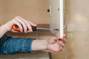 Kadın evde tornavidayla mobilya tamir ediyor. Ev konseptini onar.