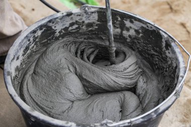 Çimento bazlı yapıştırıcı. Betonu elektrikli matkapla karıştırmak. İnşaat işleri için ıslak havan topu. Yakın plan. Seçici odak.