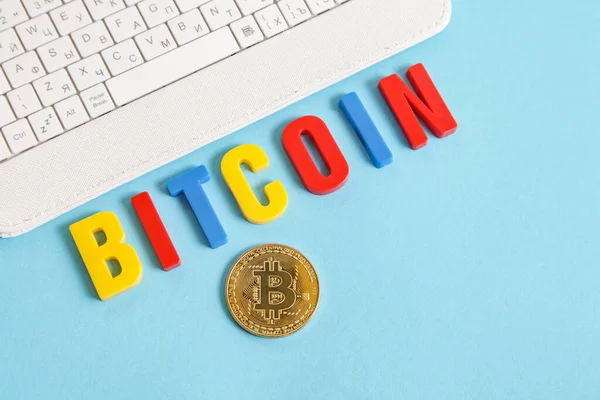 Cryptocurrency for kids. White keyboard, Bitcoin word from colorful letters on blue background — Stock Photo, Image