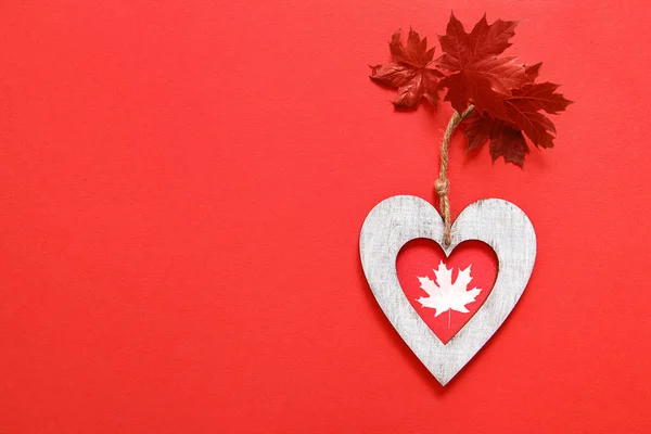 Happy Canada day greeting card. Leaf Maple, Heart on red background. Copy space