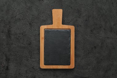 Kahverengi ahşap yontmalı siyah taş, siyah taş masanın üzerinde. Kopyalama alanı olan üst görünüm. Kırsal yemekler.